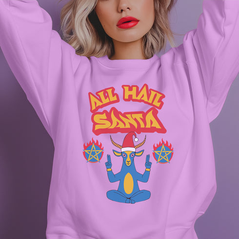 A Christmas sweatshirt featuring a playful design with a cartoon Baphomet goat character wearing a Santa hat. The design includes the text "All Hail Santa" above the goat, with pentagrams in flames on either side. The goat is depicted in a meditative pose, adding a humorous and irreverent twist to holiday attire.